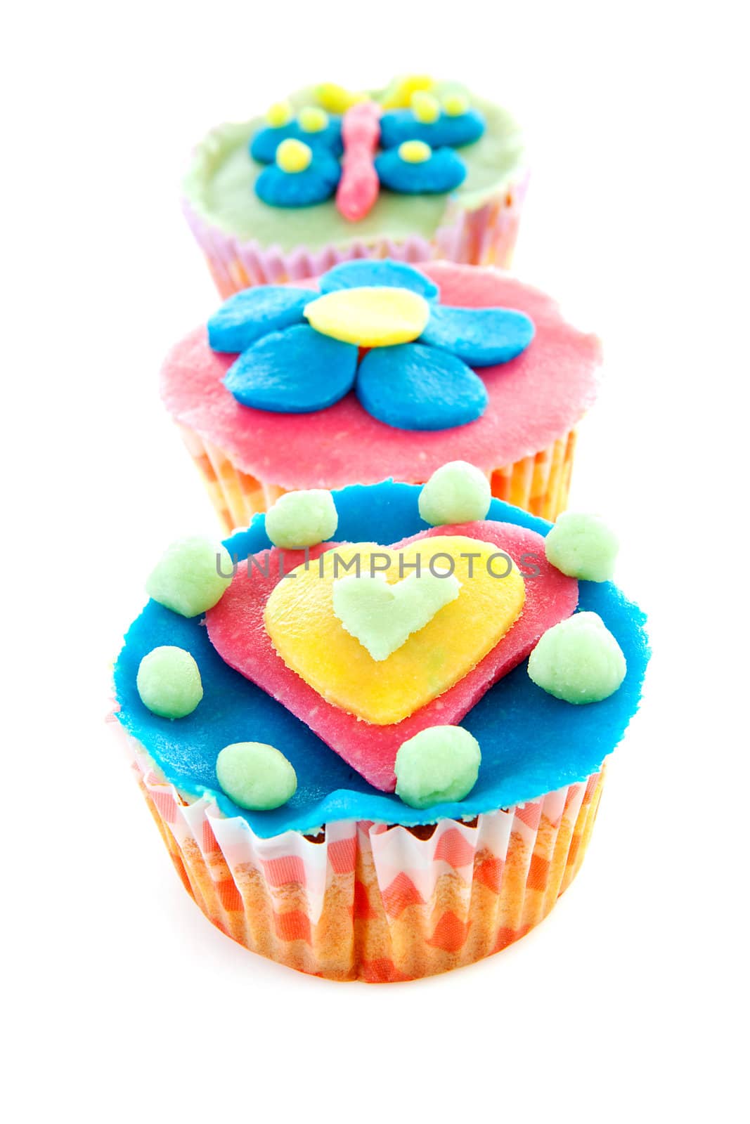 three cupcakes with marzipan decoration over white background