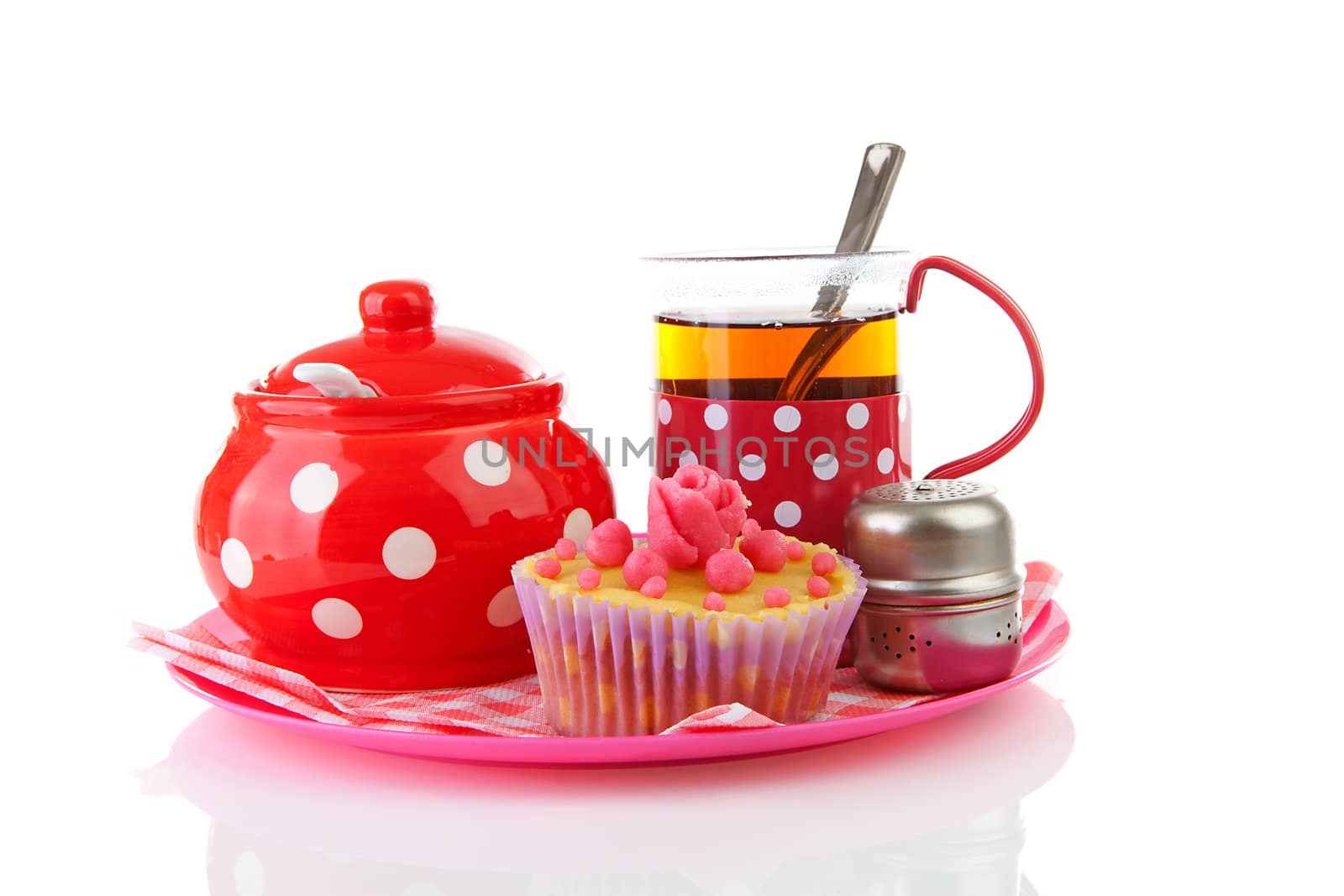 Plate with cup of tea and cupcake over white background
