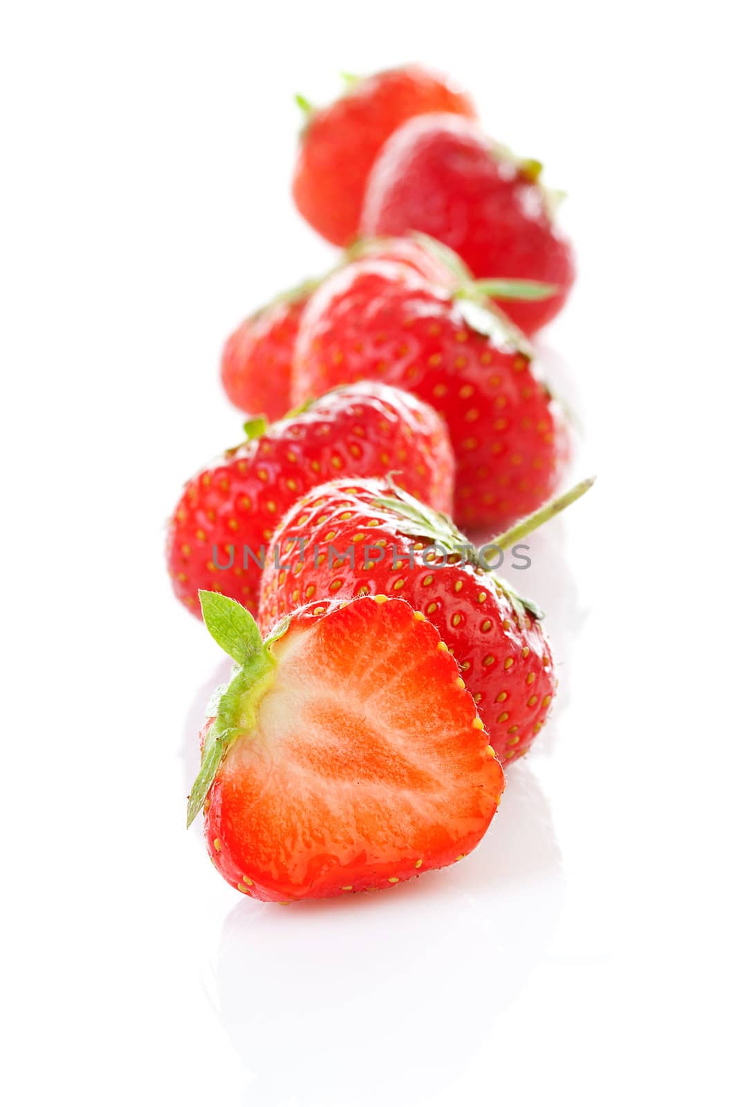 Row of fresh strawberries in closeup over white background