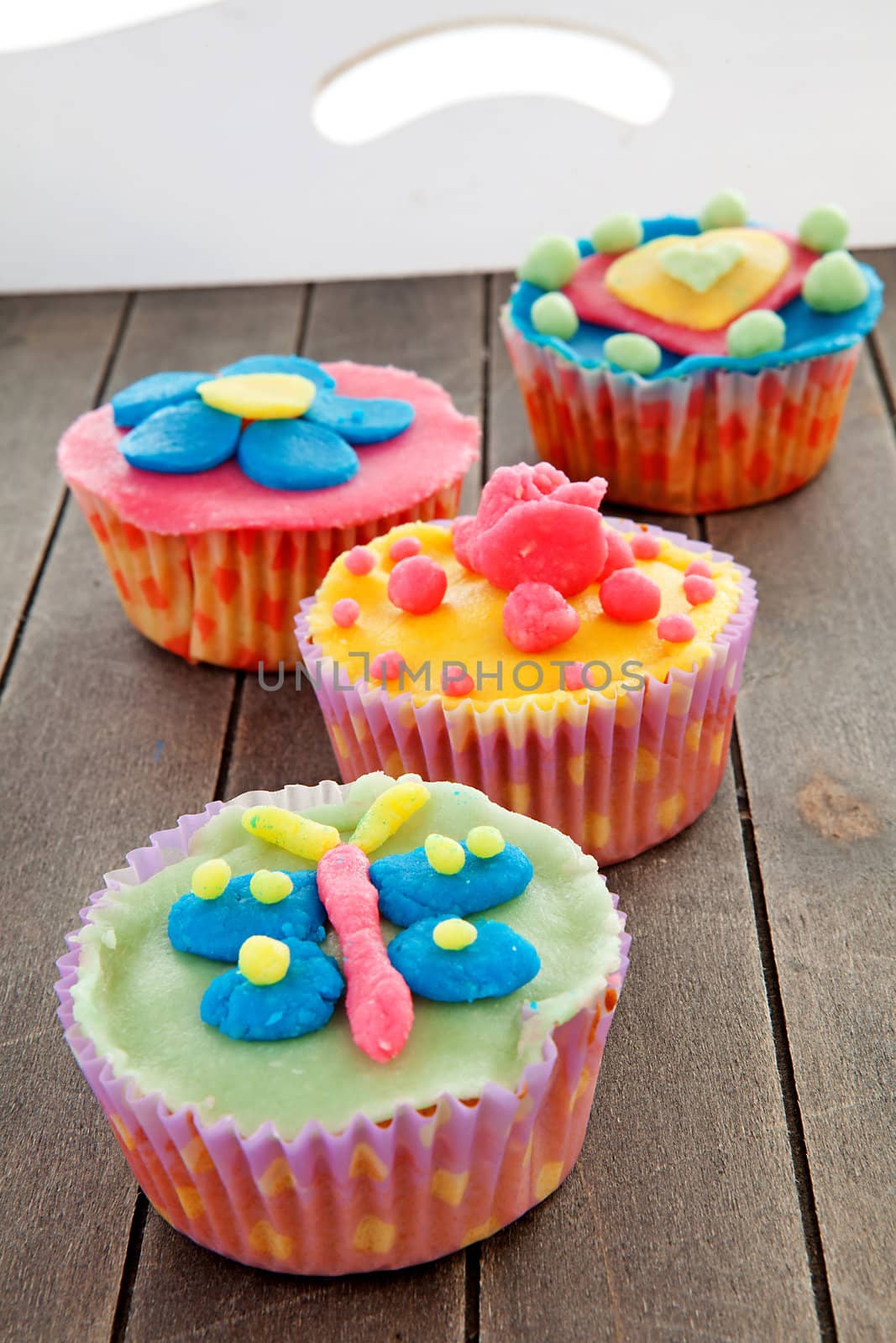 Tray with four delicious decorated colorful cupcakes
