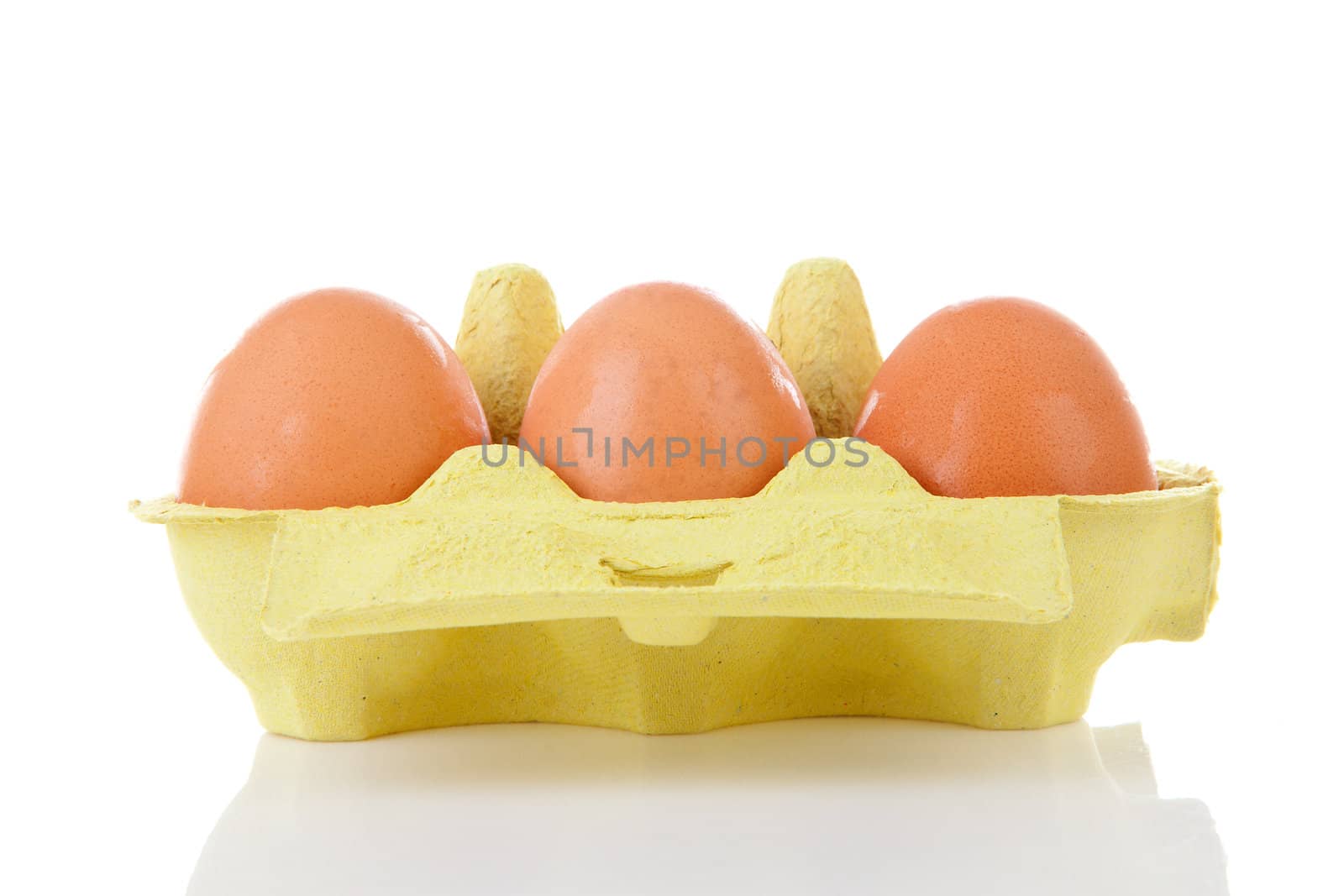 Chicken eggs in yellow carton box over white background