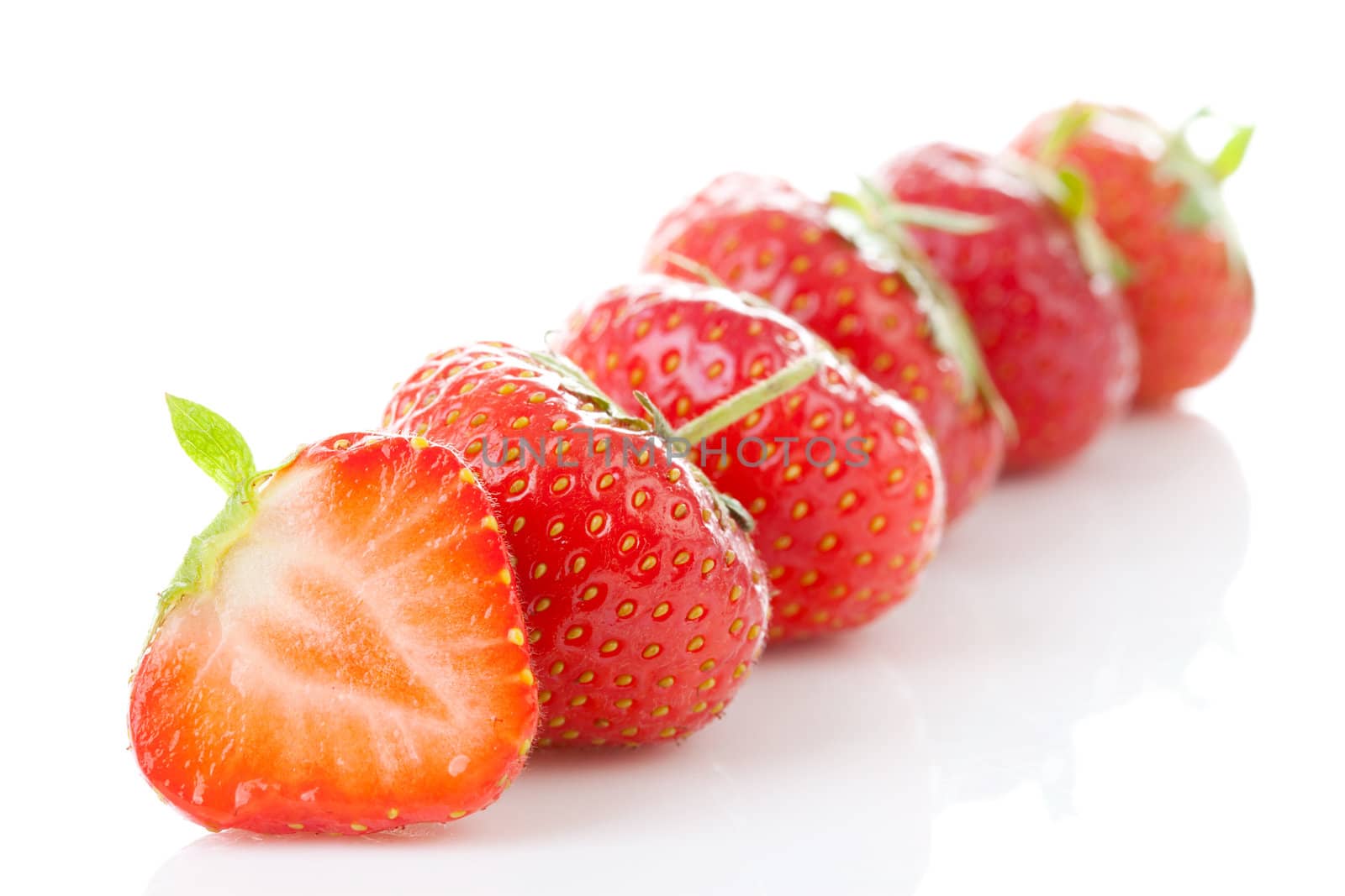 Row of fresh strawberries in closeup over white background
