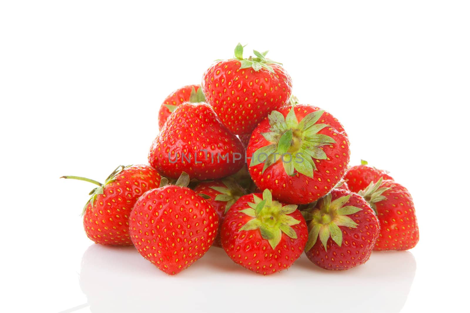 Pile of fresh strawberries in closeup over white background