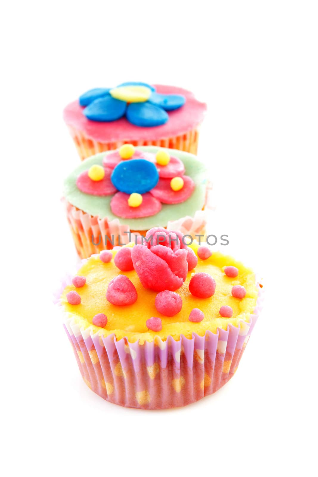 three cupcakes with marzipan decoration over white background