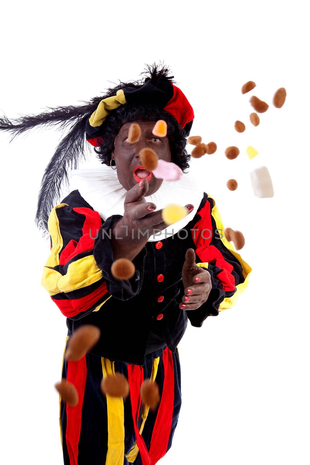 Zwarte piet ( black pete) typical Dutch character part of a traditional event celebrating the birthday of Sinterklaas in december over white background throwing pepernoten ( ginger nuts) 