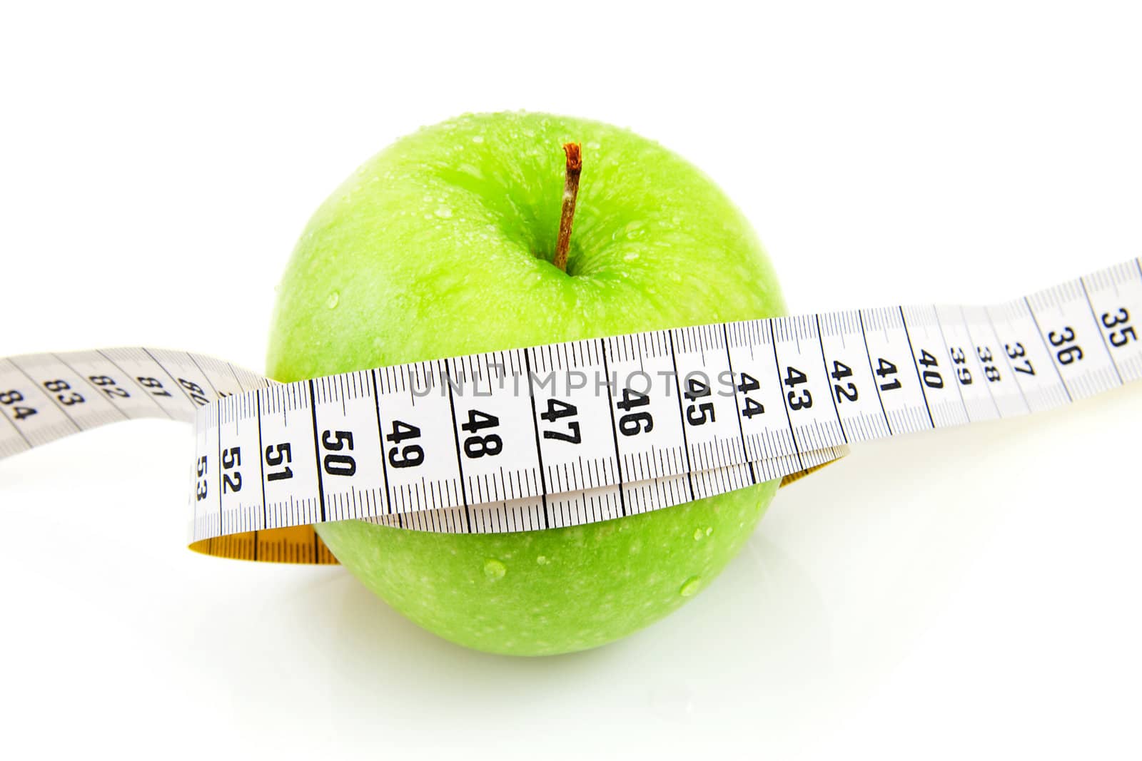 Fresh green apple with measure tape over white background