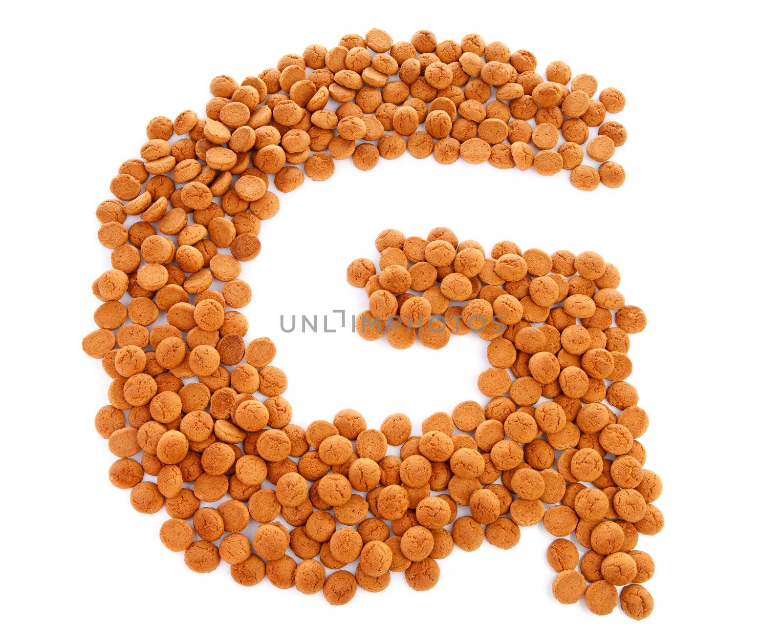 Ginger nuts, pepernoten, in the shape of letter G isolated on white background. Typical Dutch candy for Sinterklaas event in december