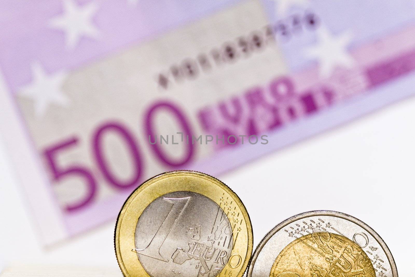 Shiny euro coins on a background of blurry 500 euro note