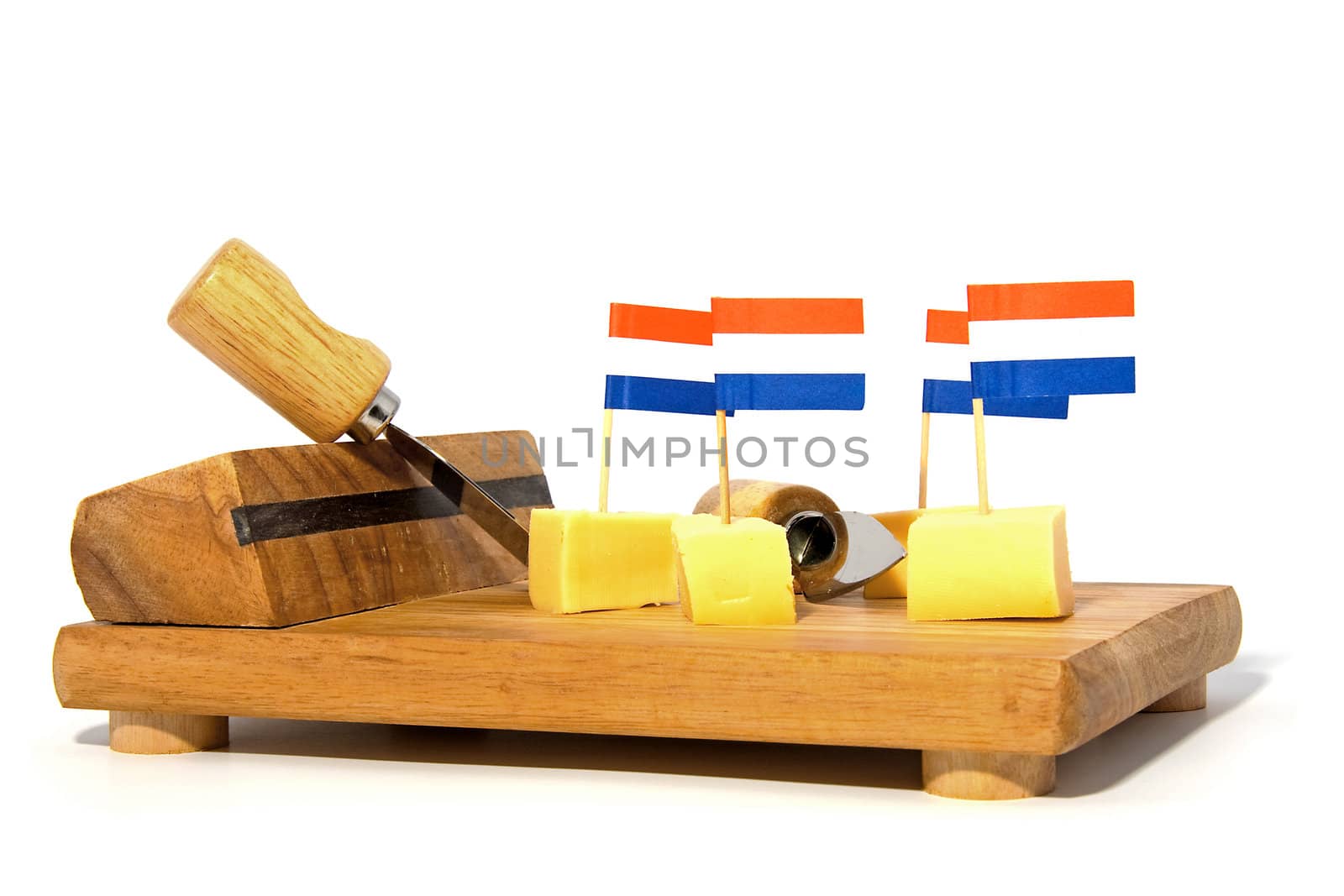 cheese cubes on wooden board with Dutch flags for party over white background