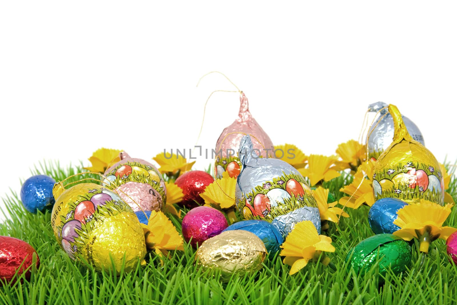 chocolate easter eggs on graas over white background