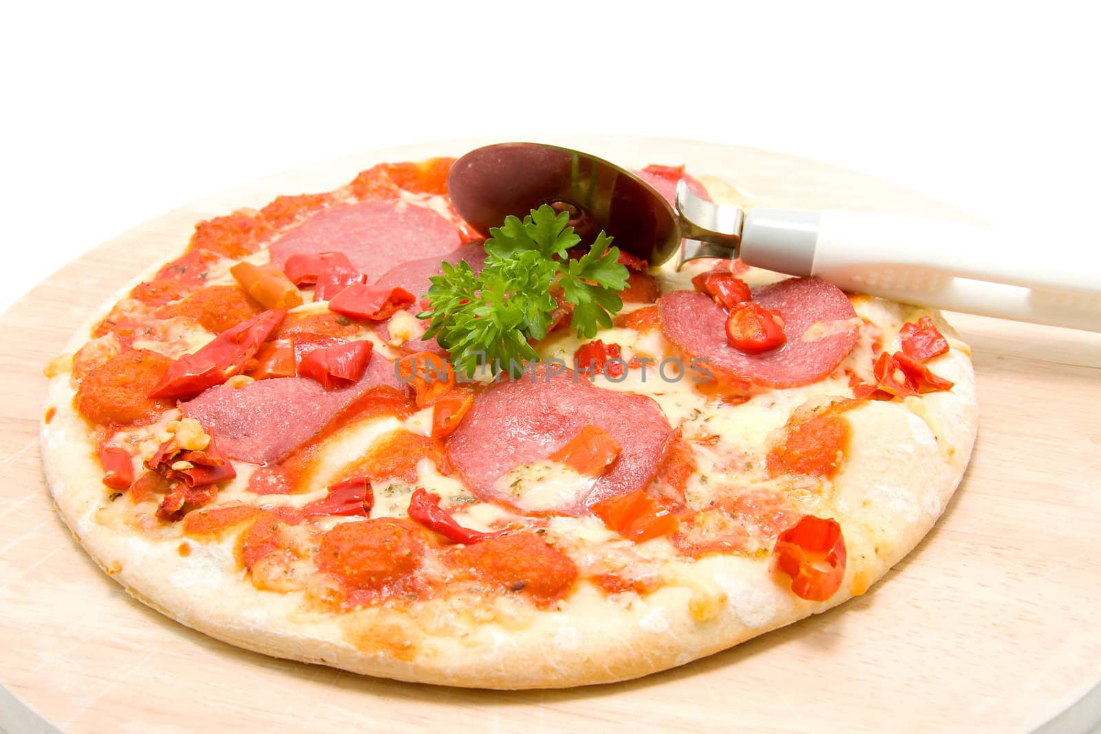 Tasty pizza with salami on wooden board over white background