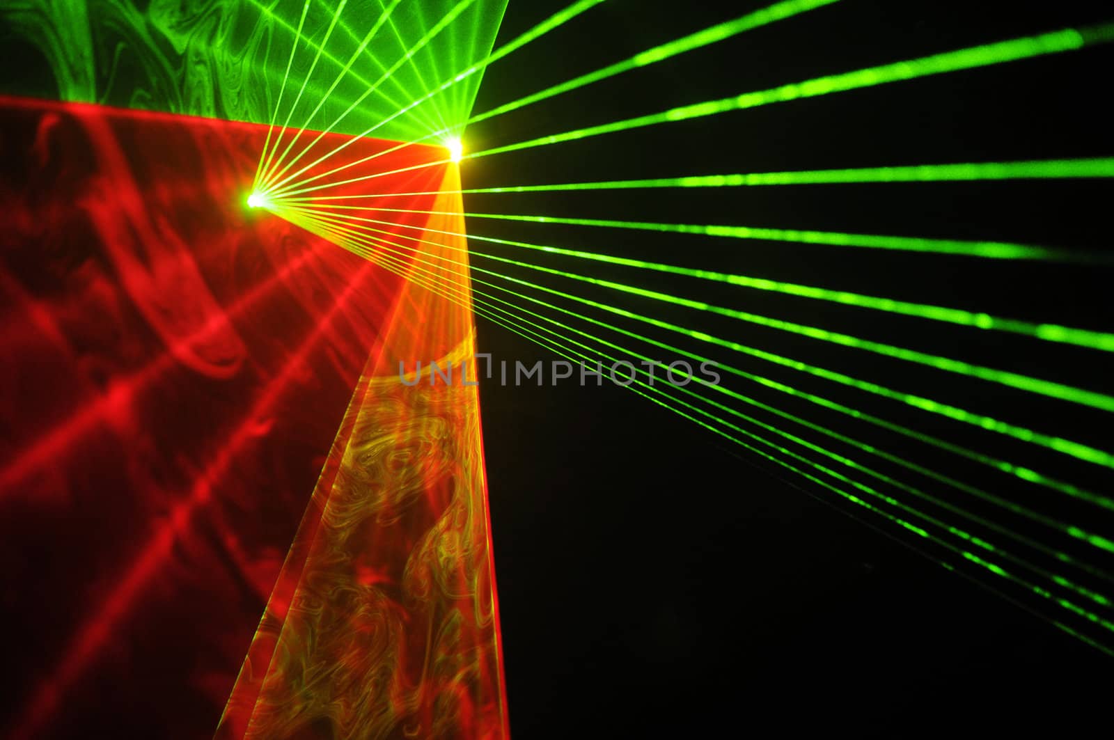 Colour lasers in smoke on a black background.