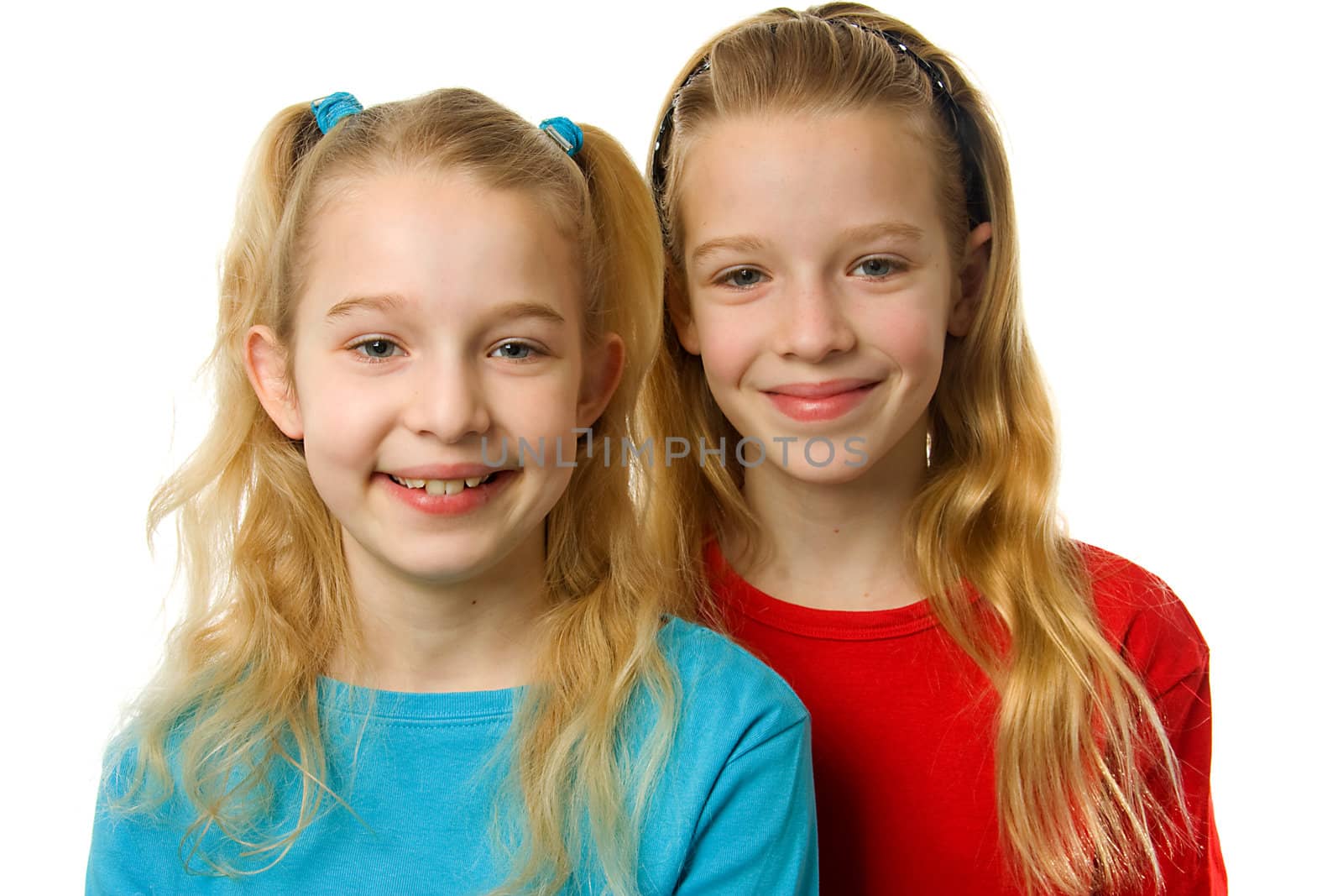 portrait of two young blonde girls looking in camera over white background