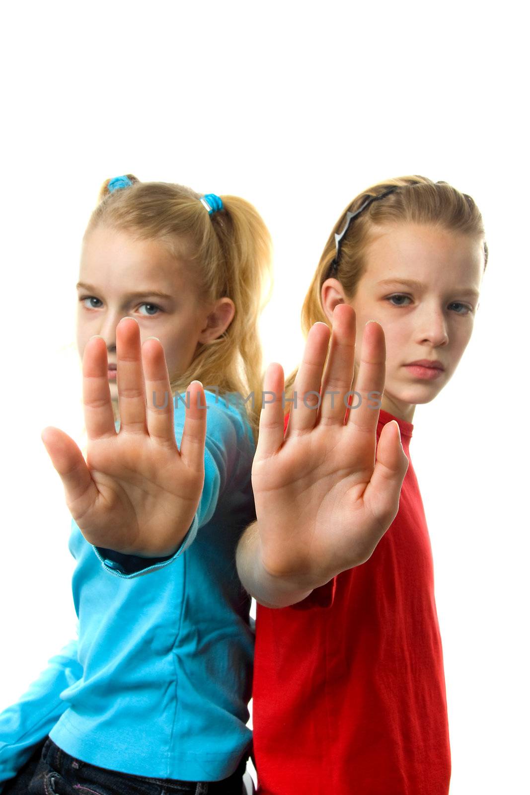 two caucasian girls making stop sign with hands over white background