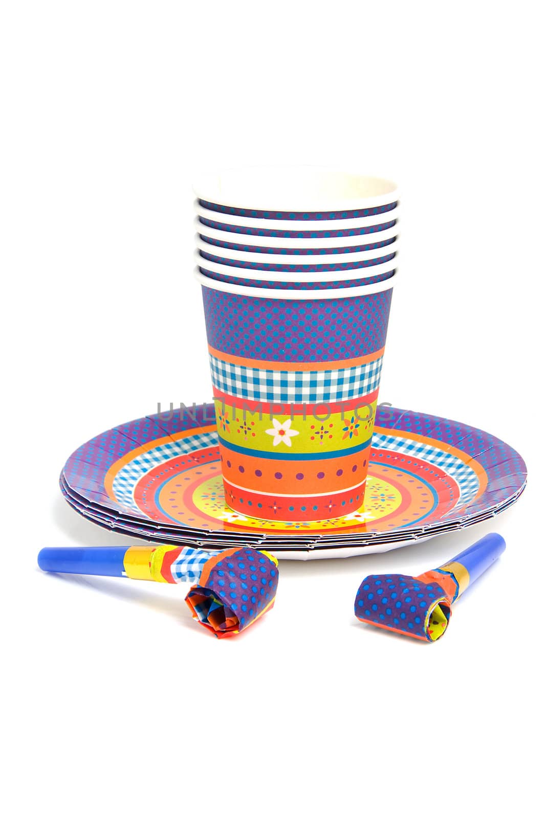 stack of birthday plates and cups with noisemakers isolated on white background