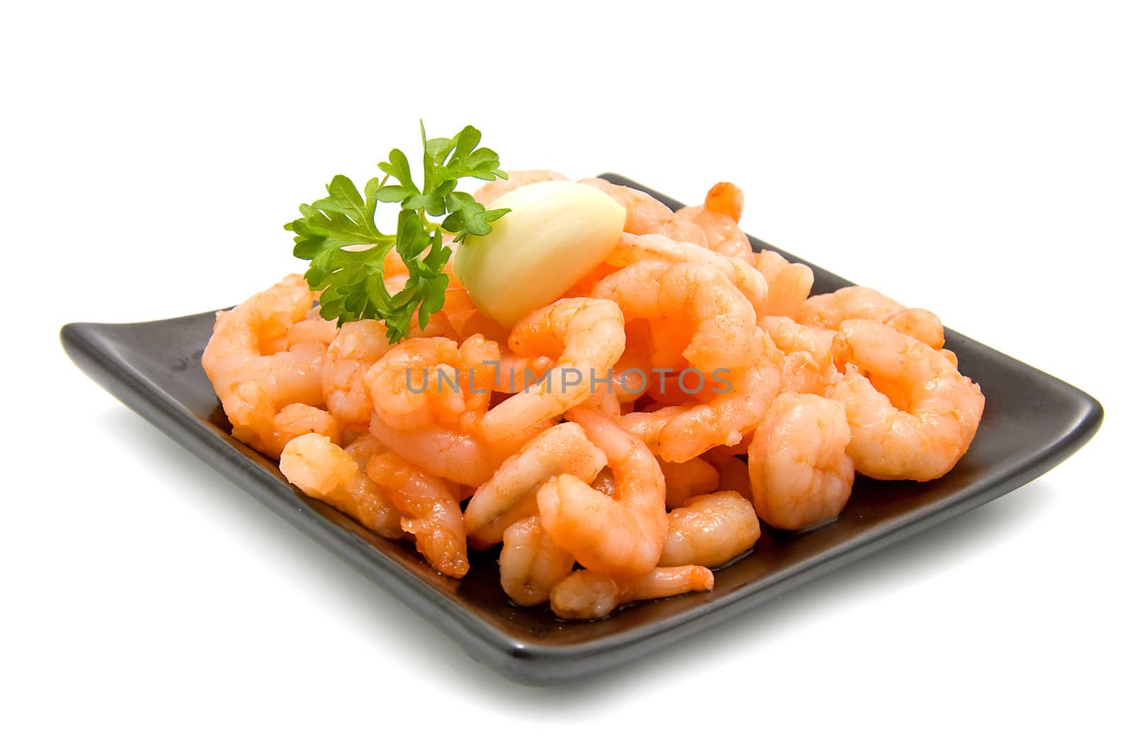 black plate with fresh raw orange shrimp over white background