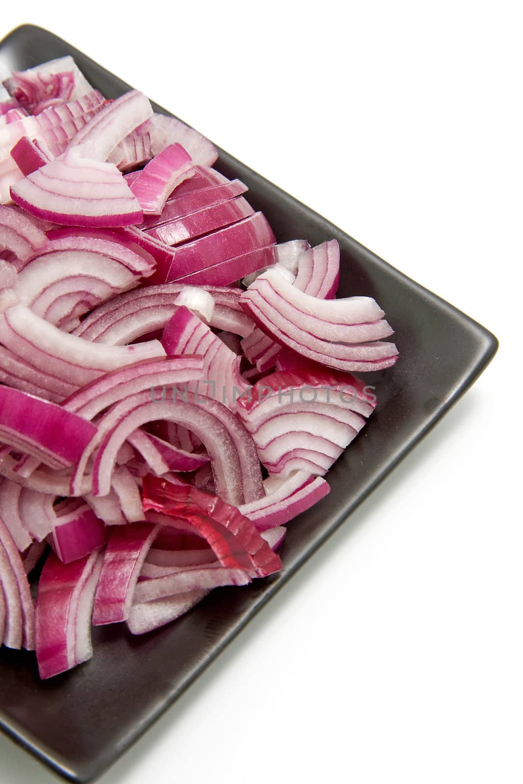 black plate with sliced red onion isolated on white background