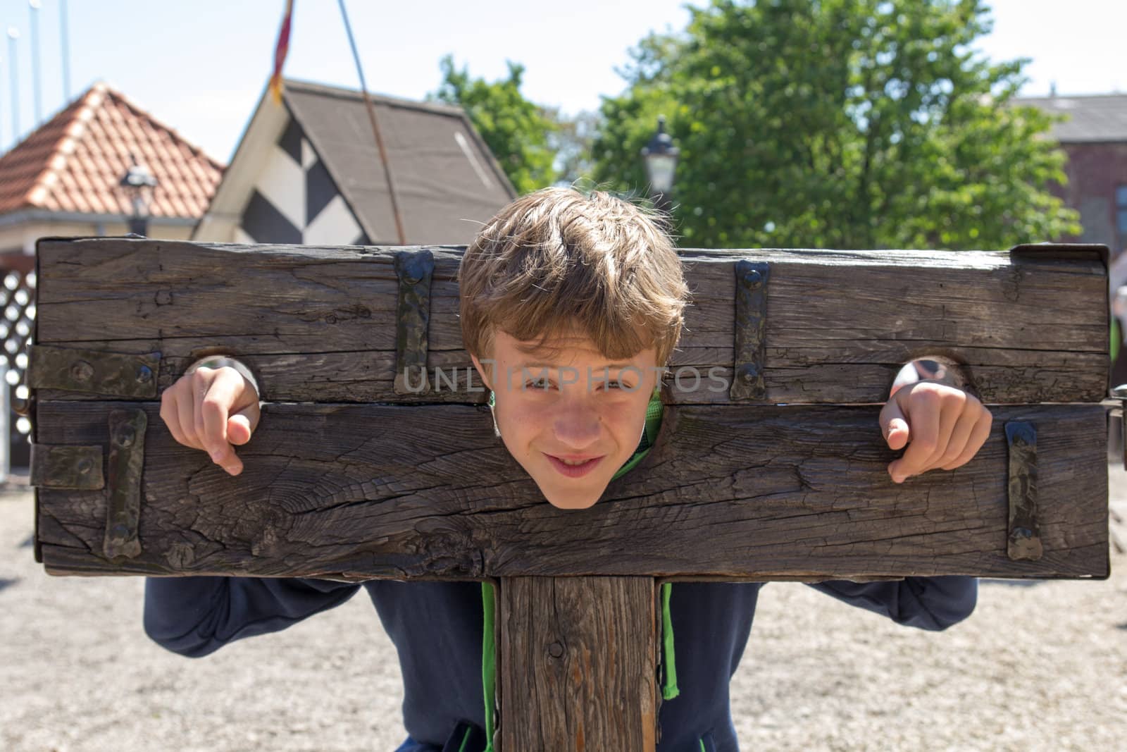 a boy trapped in a medieval torture device
