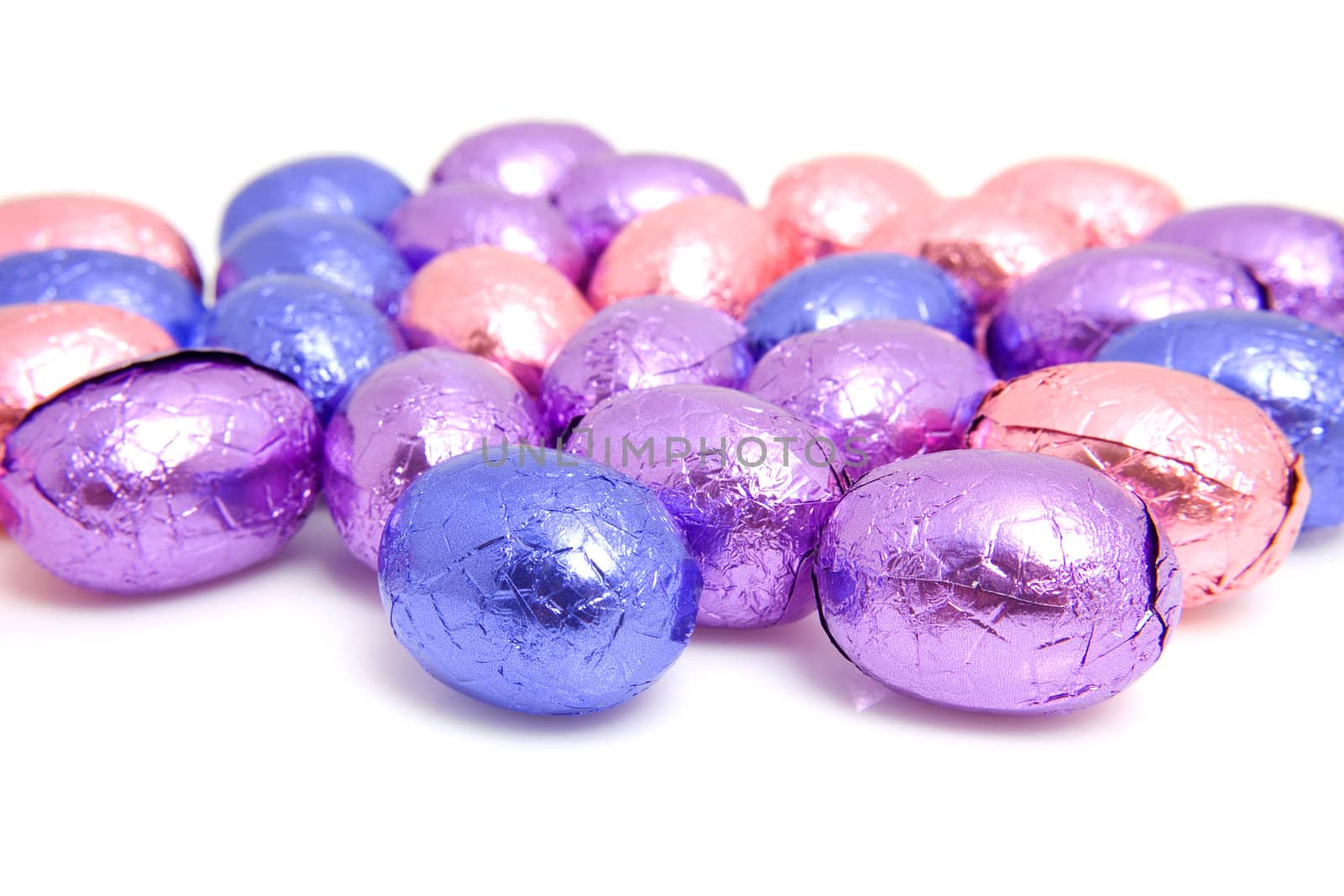 colorful chocolate easter eggs in closeup over white background