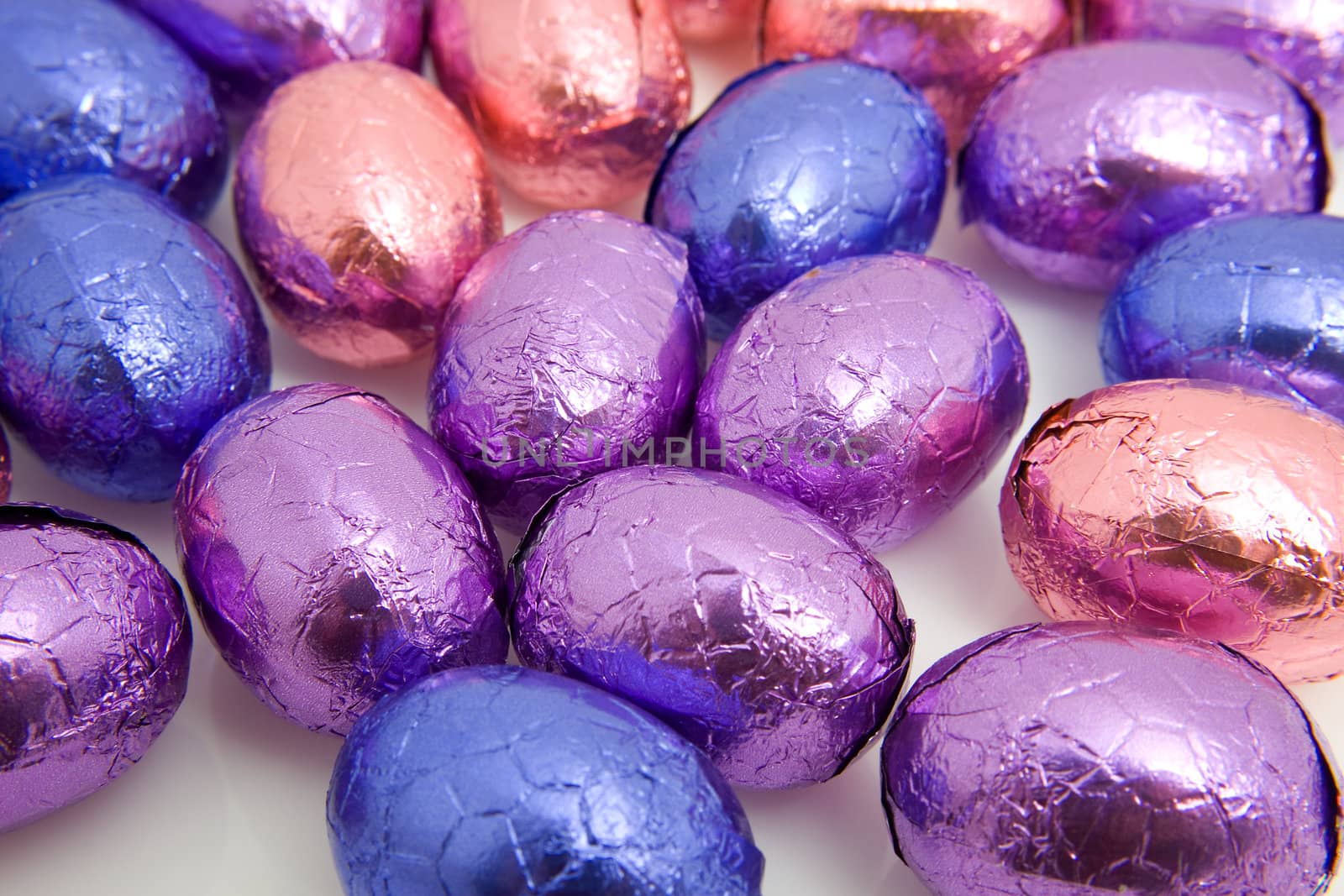 colorful chocolate easter eggs in closeup over white background