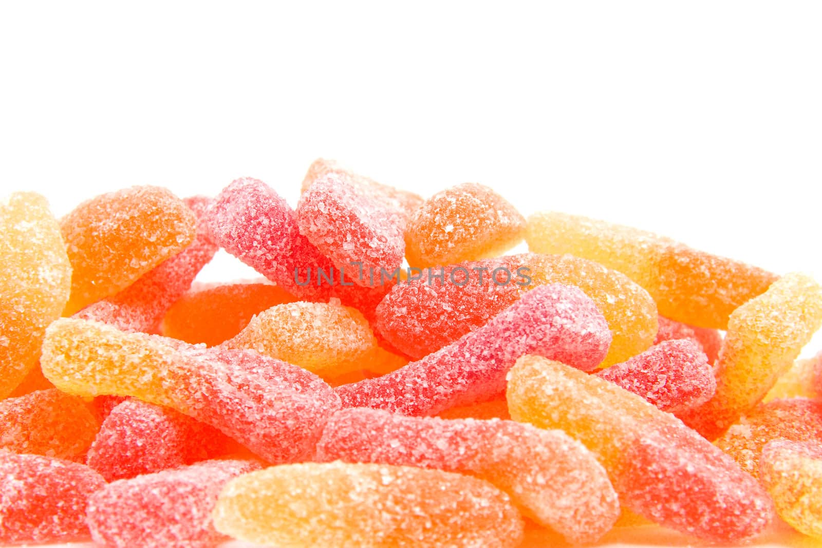 Pile of colorful sugar candy in closeup over white background
