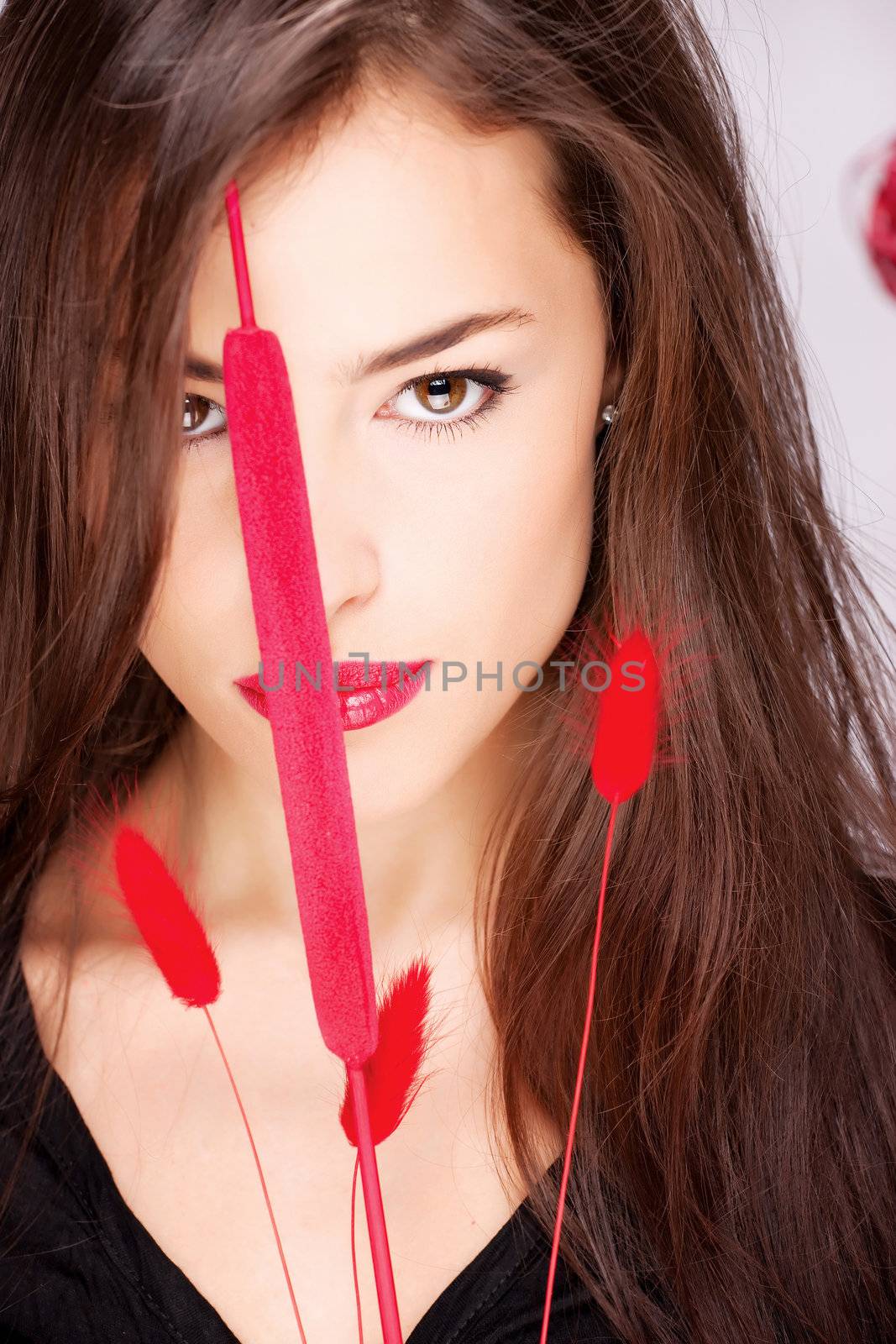 Portrait of a pretty long hair woman behind red plant