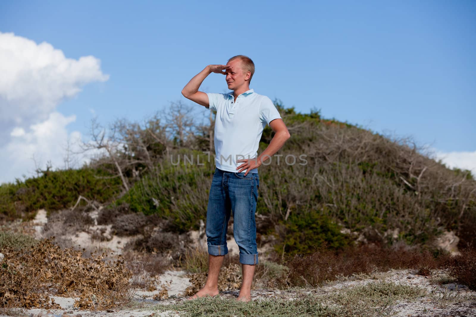 young man is relaxing outdoor in dune in summer vacation