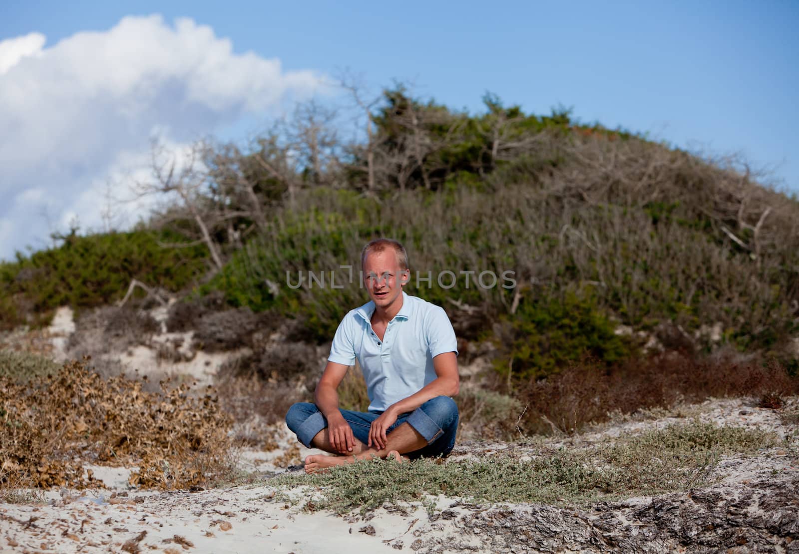 young man is relaxing outdoor in dune in summer vacation