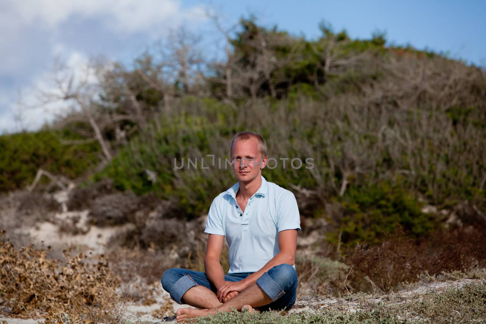 young man is relaxing outdoor in dune in summer vacation