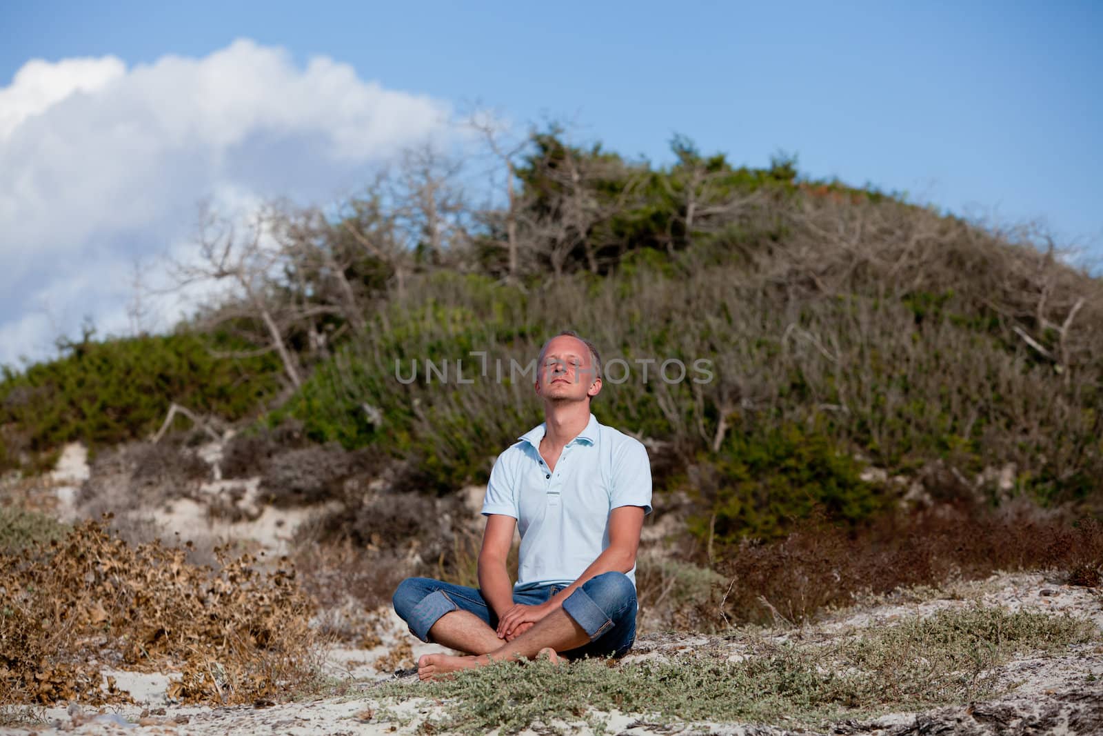 young man is relaxing outdoor in dune in summer vacation