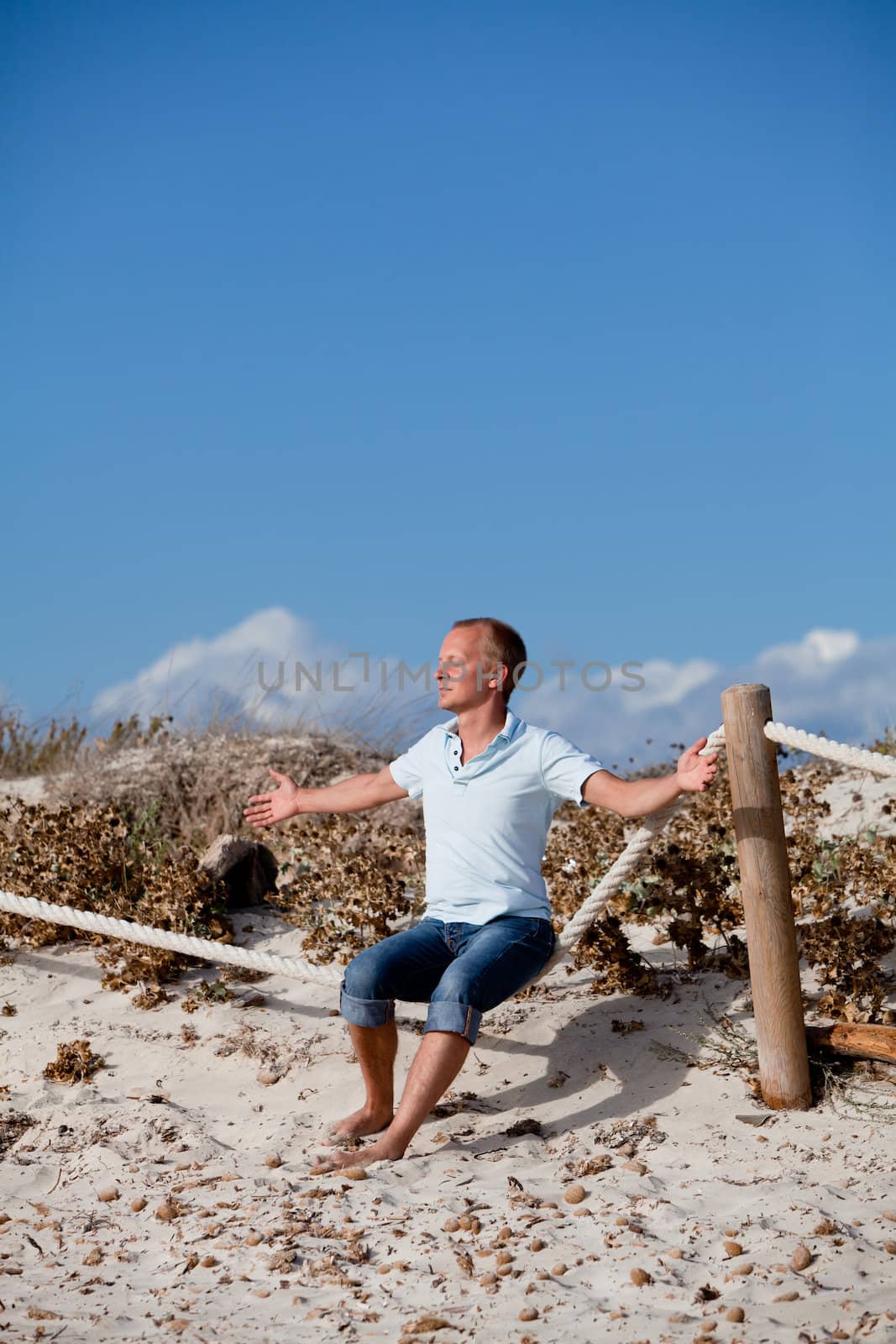 young man is relaxing outdoor in dune in summer vacation