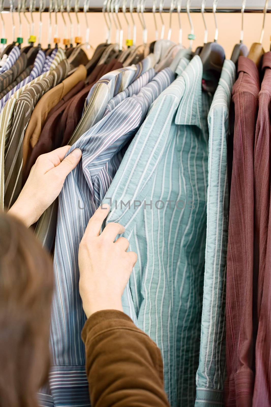 Woman's hands on shirts in the store