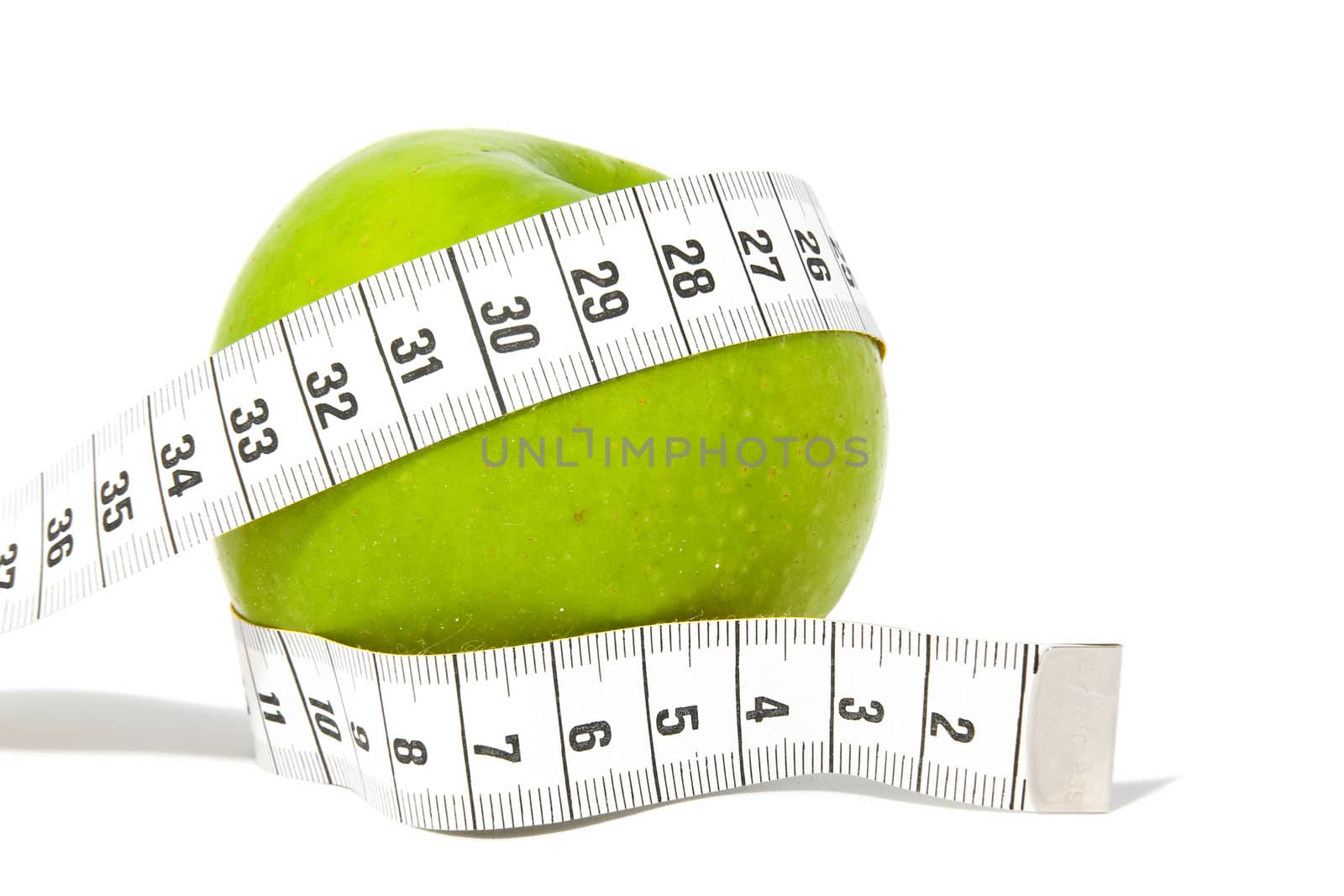 Green apple with measure tape over white background