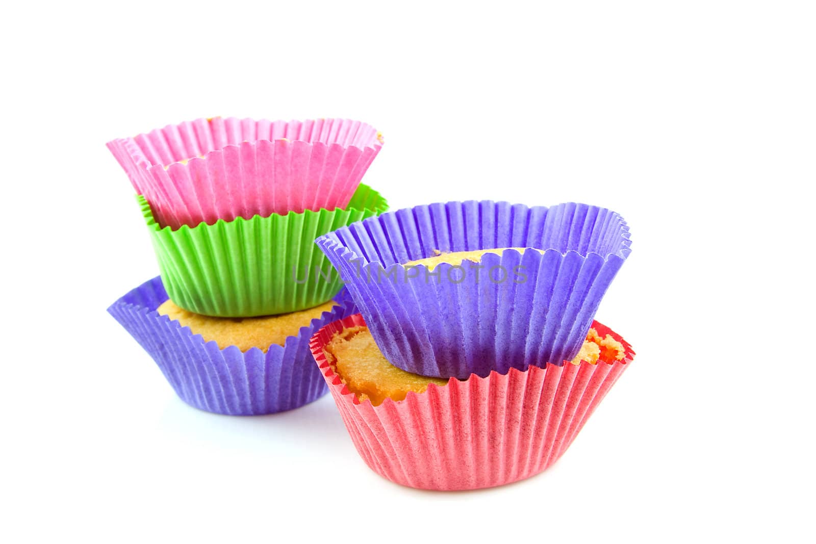 stack of colorful home baked cupcakes over white background