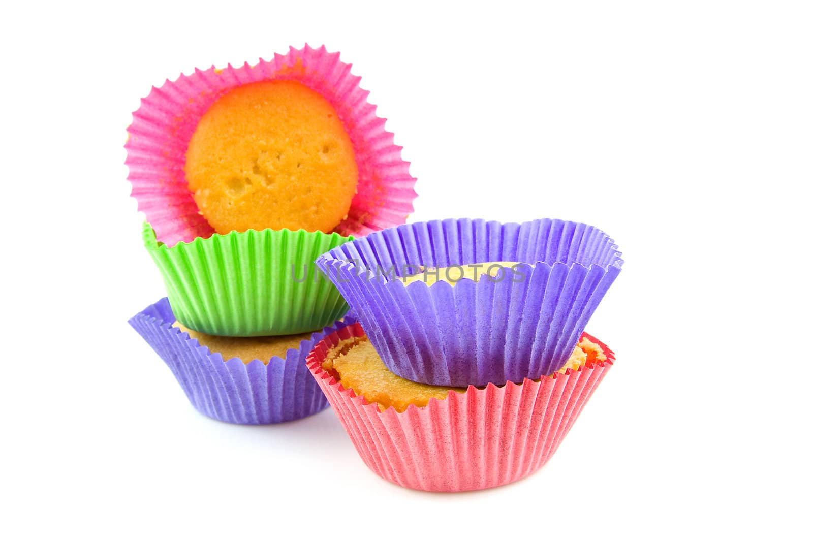 stack of colorful home baked cupcakes over white background