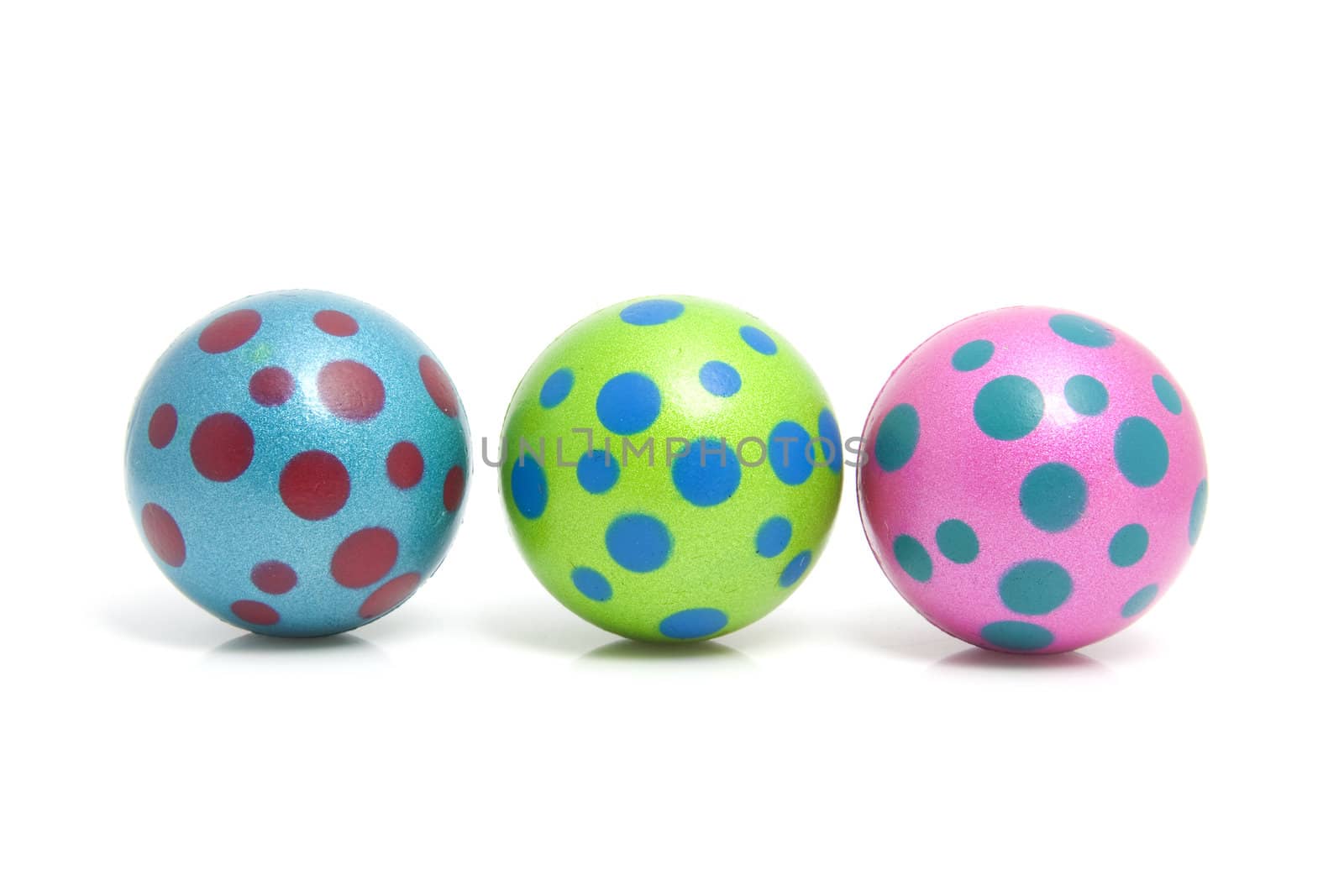 Three colorful dotted balls over white background