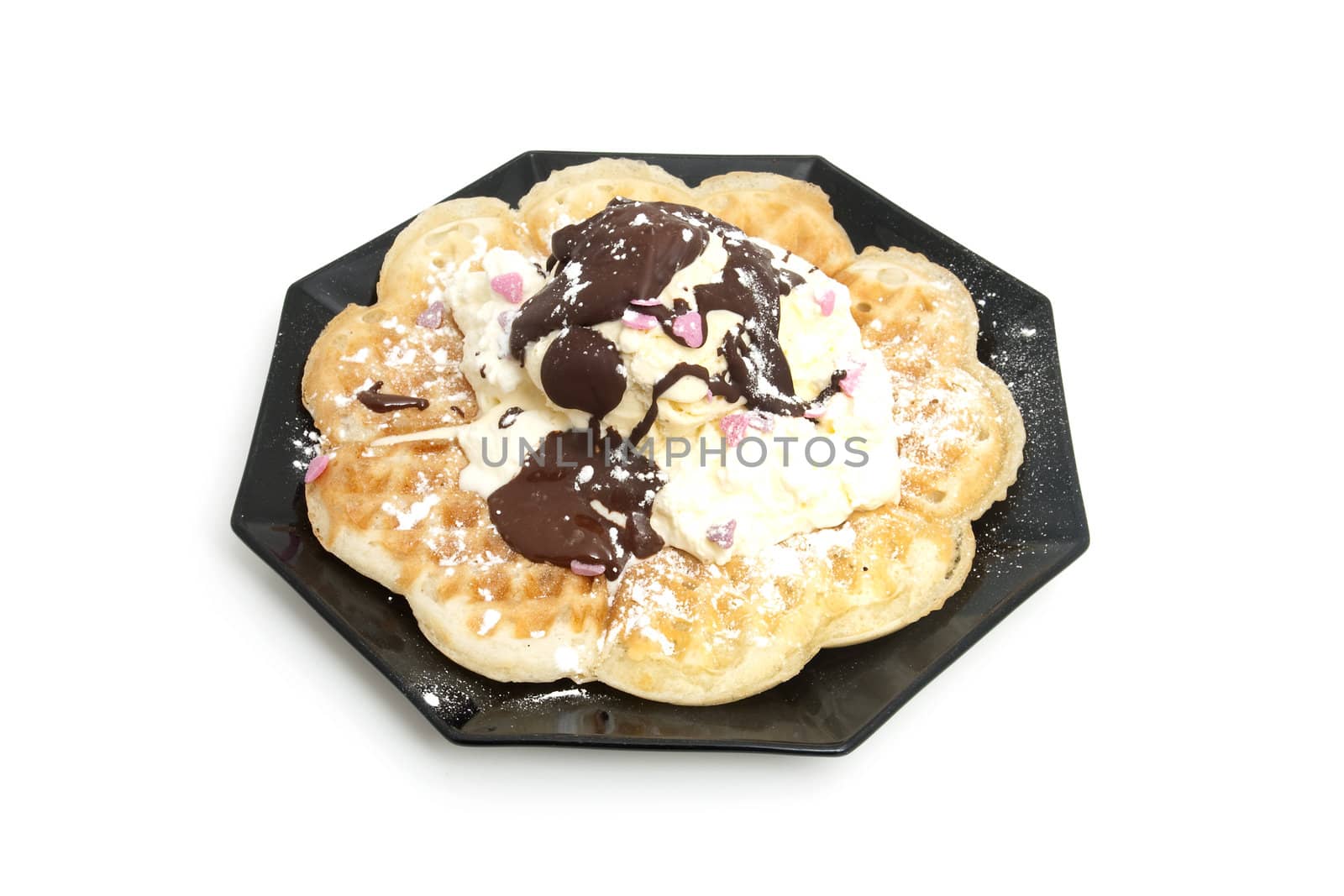 delicious dessert with waffle and ice cream on black plate over white background