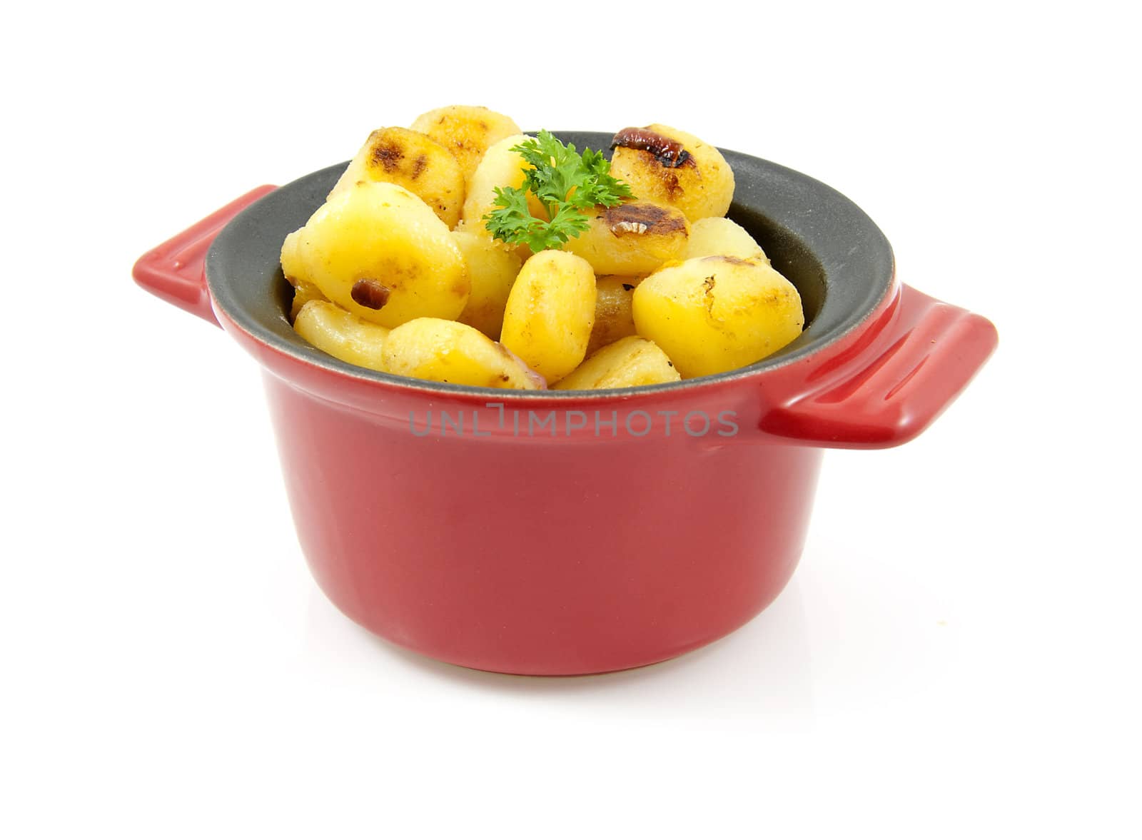 red pan with fresh baked potatoes over white background
