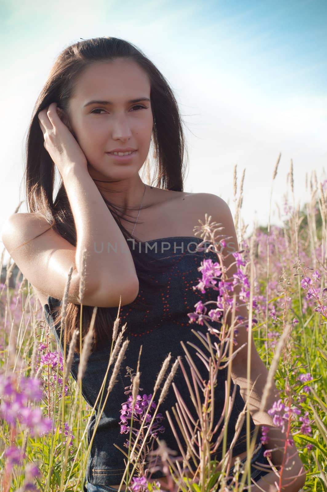 Outdoor shot of beautiful brunette woman with long hair in field