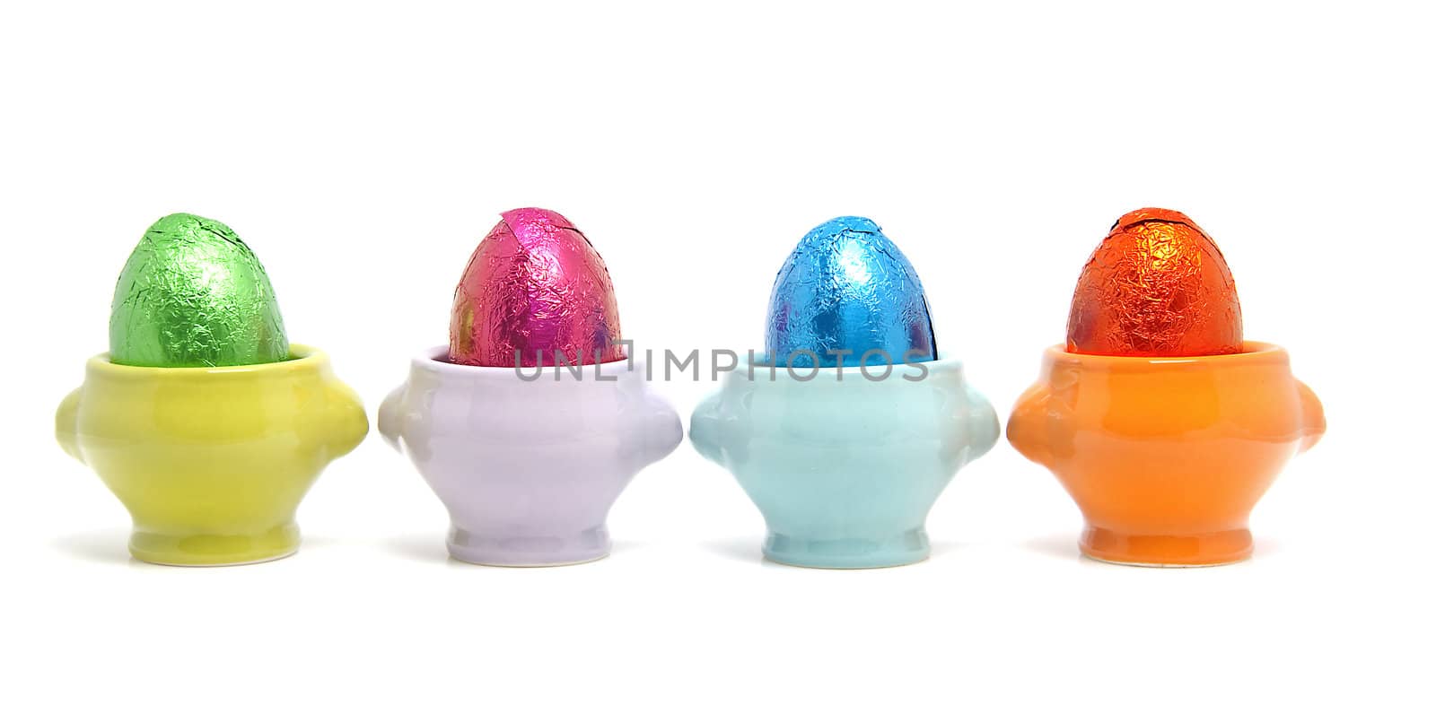 colorful easter eggs in cups isolated on white background