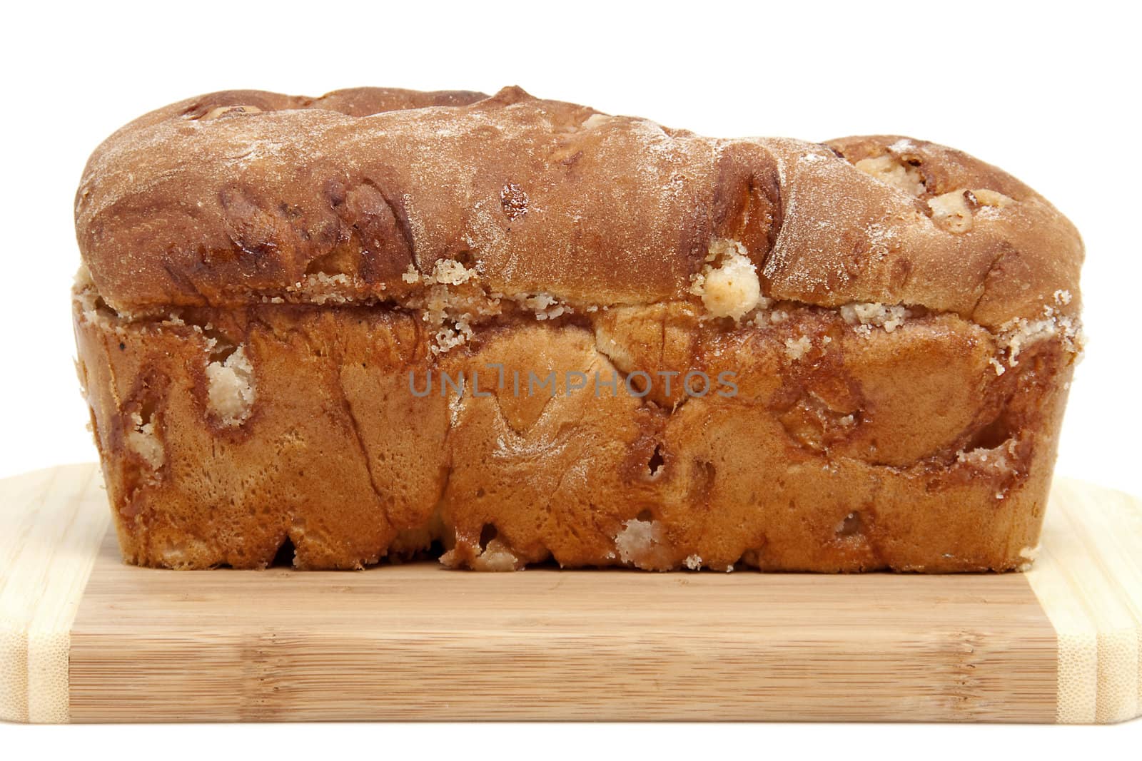 baked sugar bread in closeup on cutting board over white background