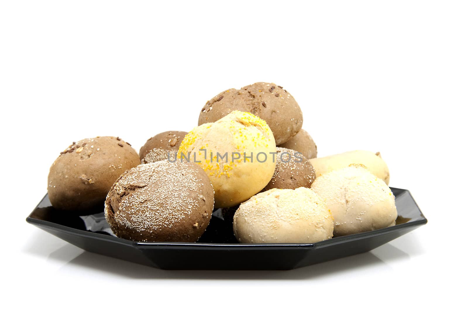 Black plate with fresh baked buns over white background