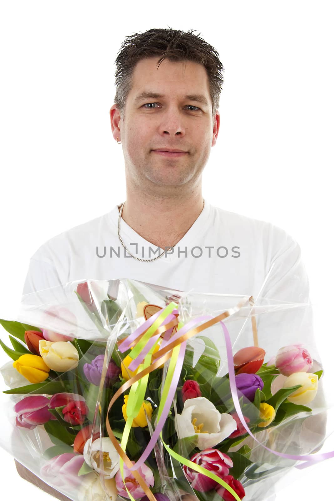 Young man is giving bouquet of colorful tulips over white background