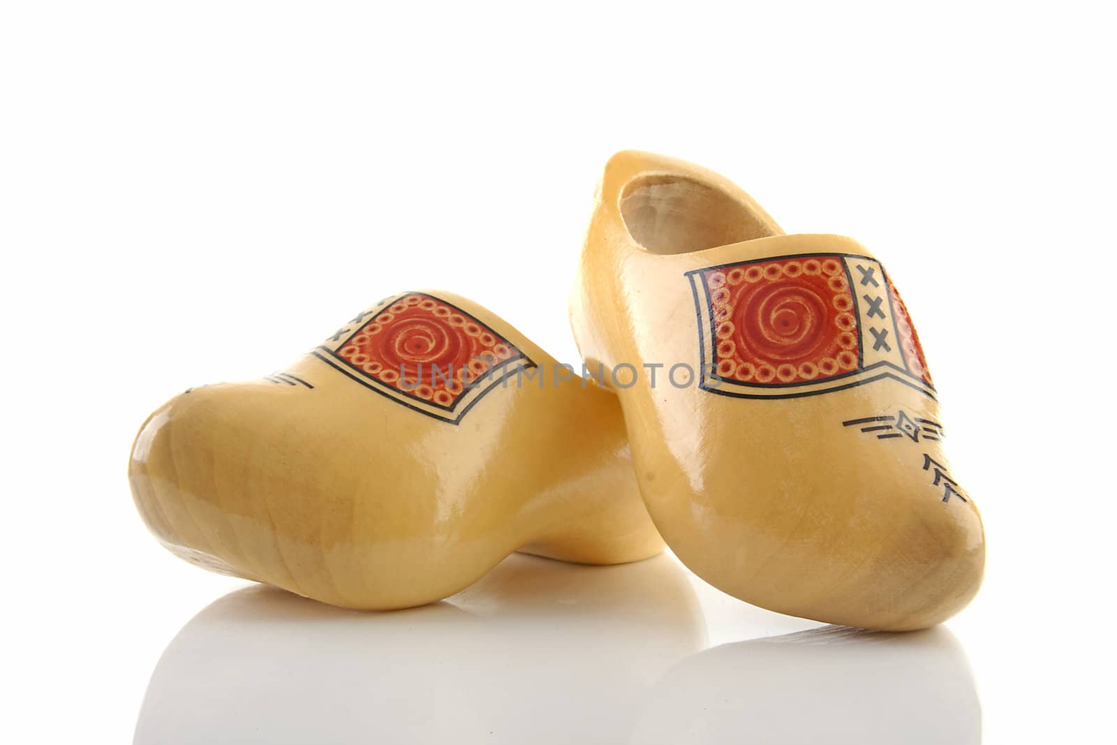 Pair of traditional yellow wooden shoes isolated on white background