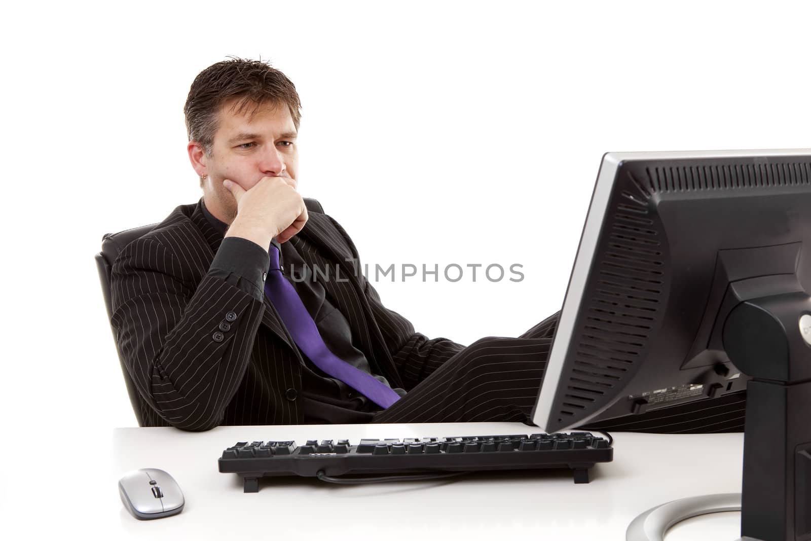 Businessman sitting behind desk is thinking over white background