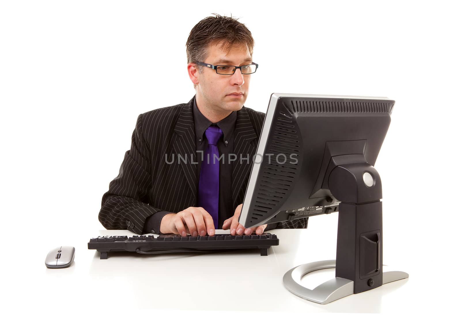 Businessman sitting behind desk at work over white background