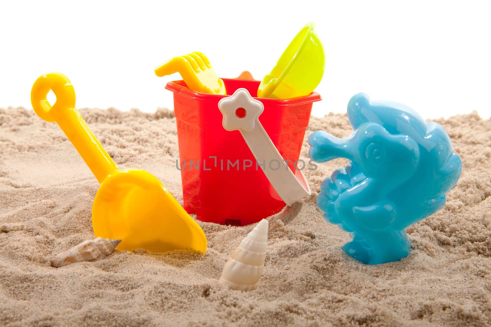 plastic toys for beach on sand over white background