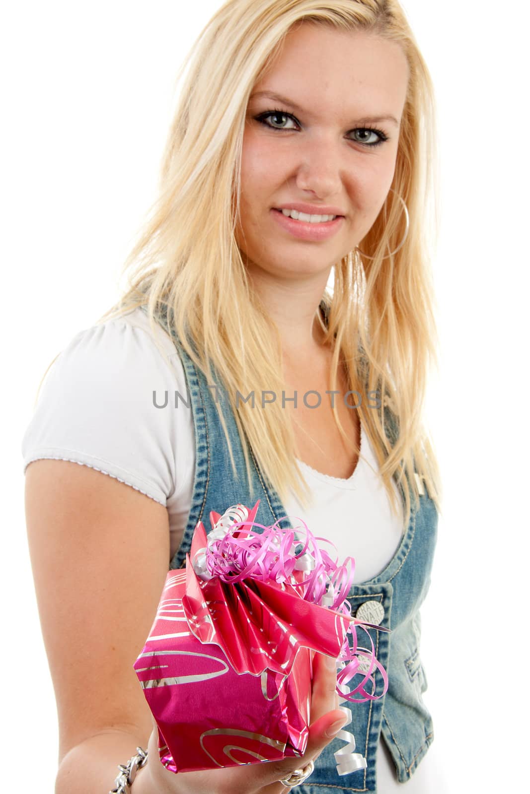 Young blonde woman is giving present, with focus on present and woman in blur, over white background