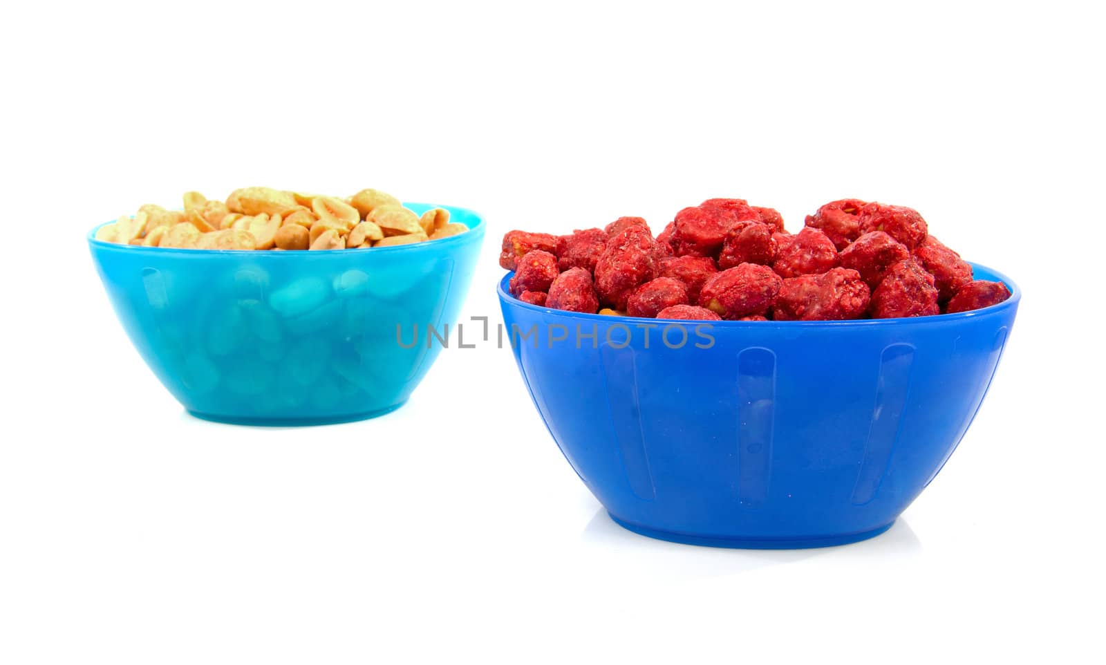 bowls with sugared and salted peanuts over white background