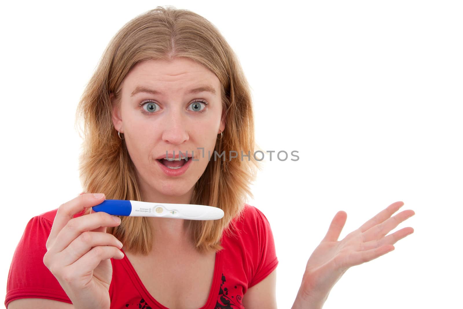 Woman is happy because she is pregnant and is showing her test with big eyes over white background